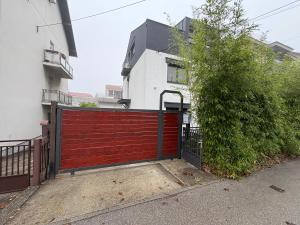 un cancello rosso del garage davanti a una casa di Sandrina a Zagabria