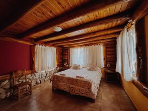 een slaapkamer met een bed in een houten huis bij Cabañas Aike in Caviahue