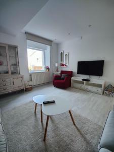 een woonkamer met een bank en een tv bij Tu Casina del Norte in Luanco