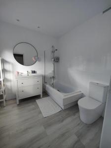 een badkamer met een bad, een toilet en een wastafel bij Tu Casina del Norte in Luanco