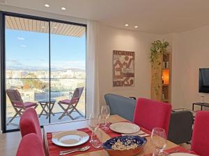 a dining room with a table and chairs and a window at Prince Delmar Waterfront Olhao by Junto ao Mar in Olhão