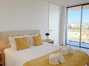 a bedroom with a large bed with towels on it at Prince Delmar Waterfront Olhao by Junto ao Mar in Olhão +42 photos