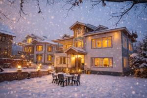 a house with a table and chairs in the snow at Gulmarg Palace Resorts in Gulmarg