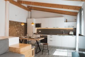 eine Küche mit weißen Schränken und einem Holztisch in der Unterkunft Casa súper acollidora completament reformada in Saldet