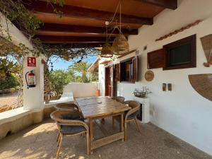 a wooden table and chairs on a patio at Michel Dos apartamentos in San Ferrán de ses Roques