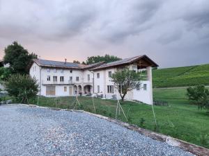 a house on a hill with a gravel driveway at Monforte Country House in Monforte dʼAlba