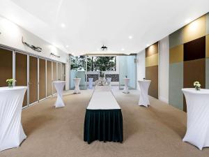een kamer met witte tafels en witte stoelen bij The Sebel Maroochydore in Maroochydore