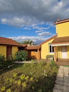 a yellow house with a bench in a yard at Chambre Privée avec Jardin in Clermont-Ferrand +8 photos