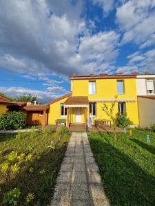 a yellow house with a pathway in front of it at Chambre Privée avec Jardin in Clermont-Ferrand