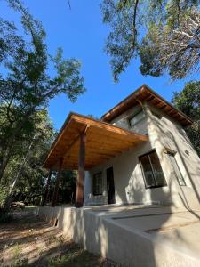een klein huis met een houten dak bij Wanna Hospedaje in Villa Ciudad Parque