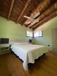 een slaapkamer met een groot bed met een plafondventilator bij Wanna Hospedaje in Villa Ciudad Parque