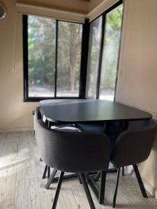 een zwarte tafel en stoelen in een kamer met ramen bij Wanna Hospedaje in Villa Ciudad Parque +17 foto's