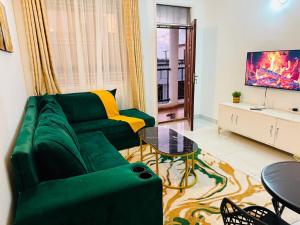 a living room with a green couch and a table at Casses Apartments in Mombasa