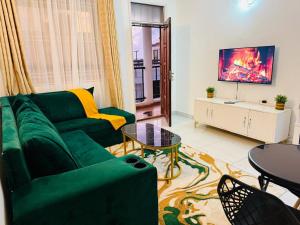a living room with a green couch and a table at Casses Apartments in Mombasa +4 photos
