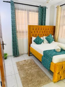a bedroom with a large bed with green curtains at Casses Apartments in Mombasa