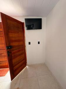 a room with a door and a television on a wall at Pousada Serena Jacumã in Conde