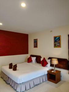 een slaapkamer met 2 bedden en rode kussens bij Phangan Orchid Resort in Baan Tai