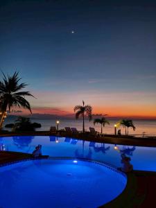 een zwembad met uitzicht op de oceaan in de nacht bij Phangan Orchid Resort in Baan Tai