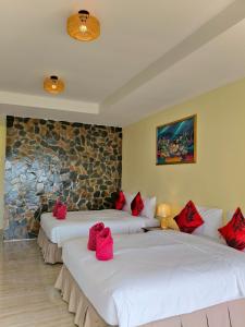 twee bedden in een kamer met rode kussens erop bij Phangan Orchid Resort in Baan Tai