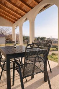 un tavolo nero e sedie su un patio di Apartman Mila a Golubić