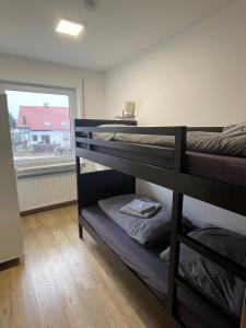 een kamer met 3 stapelbedden en een raam bij Ferienwohnung Adelsried 2 in Adelsried