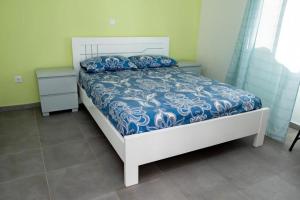 ein Schlafzimmer mit einem Bett mit einer blau-weißen Bettdecke in der Unterkunft FADIAS Quartos - Rooms in Ribeira Grande