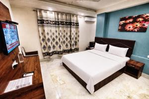 a bedroom with a bed and a flat screen tv at Hotel Delhi Aerocity in New Delhi +47 photos