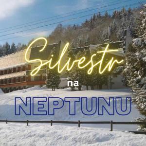 een bord voor een hotel in de sneeuw bij Horský Hotel Neptun in Malá Morávka