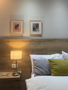 een slaapkamer met een bed met een houten hoofdeinde en een lamp bij Terra Malal in Chos Malal