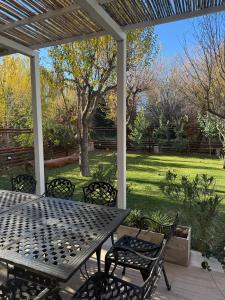 een picknicktafel en stoelen op een terras met een tuin bij Terra Malal in Chos Malal