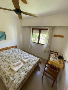een slaapkamer met een bed, een tafel en een raam bij Hotel Maresias in Villa Gesell +11 foto's