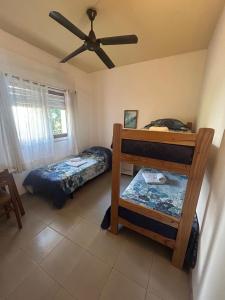 een slaapkamer met twee bedden en een plafondventilator bij Hotel Maresias in Villa Gesell