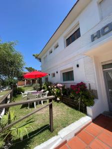 een gebouw met tafels en parasols ervoor bij Hotel Maresias in Villa Gesell