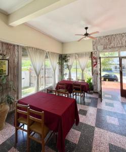 een eetkamer met tafels en stoelen en ramen bij Hotel Maresias in Villa Gesell