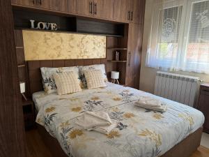 a bedroom with a bed with a love sign on it at Primavera apartments Banja Koviljaca in Banja Koviljača