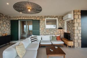 a living room with a white couch and a table at Casa Ponente in Porto Santo Stefano