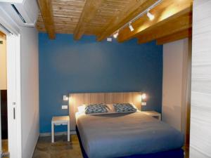 a bed in a room with a blue wall at Carme31 Sirmione in San Martino della Battaglia