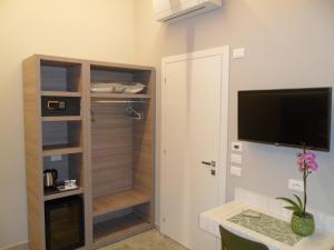 a room with a closet with a television and a desk at Carme31 Sirmione in San Martino della Battaglia