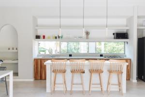 een keuken met een aanrecht met vier barkrukken bij Gaia Casa de Mar in El Bobo