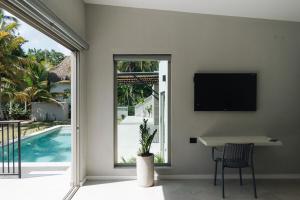 een woonkamer met een tafel en een tv aan de muur bij Gaia Casa de Mar in El Bobo