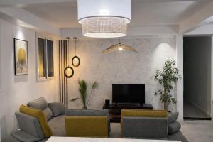 een woonkamer met een bank en een televisie bij Résidence Nakiya in Sainte-Marie