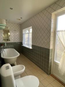 a bathroom with a toilet and a tub and a sink at Kroksta Gård in Bälinge