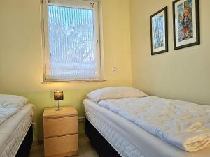 a bedroom with two beds and a window at Ferienwohnung Seestern Suite im Haus Sonnensegler in Thiessow
