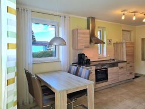 a kitchen with a wooden table and a window at Ferienwohnung Seestern Suite im Haus Sonnensegler in Thiessow