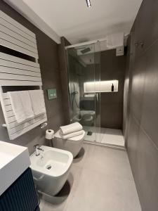 een badkamer met een toilet, een wastafel en een douche bij Loft Green Trani in Trani