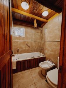 een badkamer met een bad, een toilet en een wastafel bij Cabañas Aike in Caviahue +134 foto's