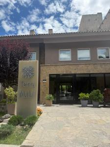 een gebouw met een bord ervoor bij Terra Malal in Chos Malal