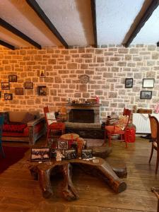 a living room with a brick wall and a table at Villa Naum in Voskopojë +12 photos