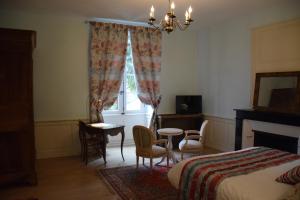 希农Au Relais Saint Maurice的一间卧室，里面有一张床、一张桌子和几把椅子。