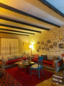a living room with a couch and a brick wall at Villa Naum in Voskopojë